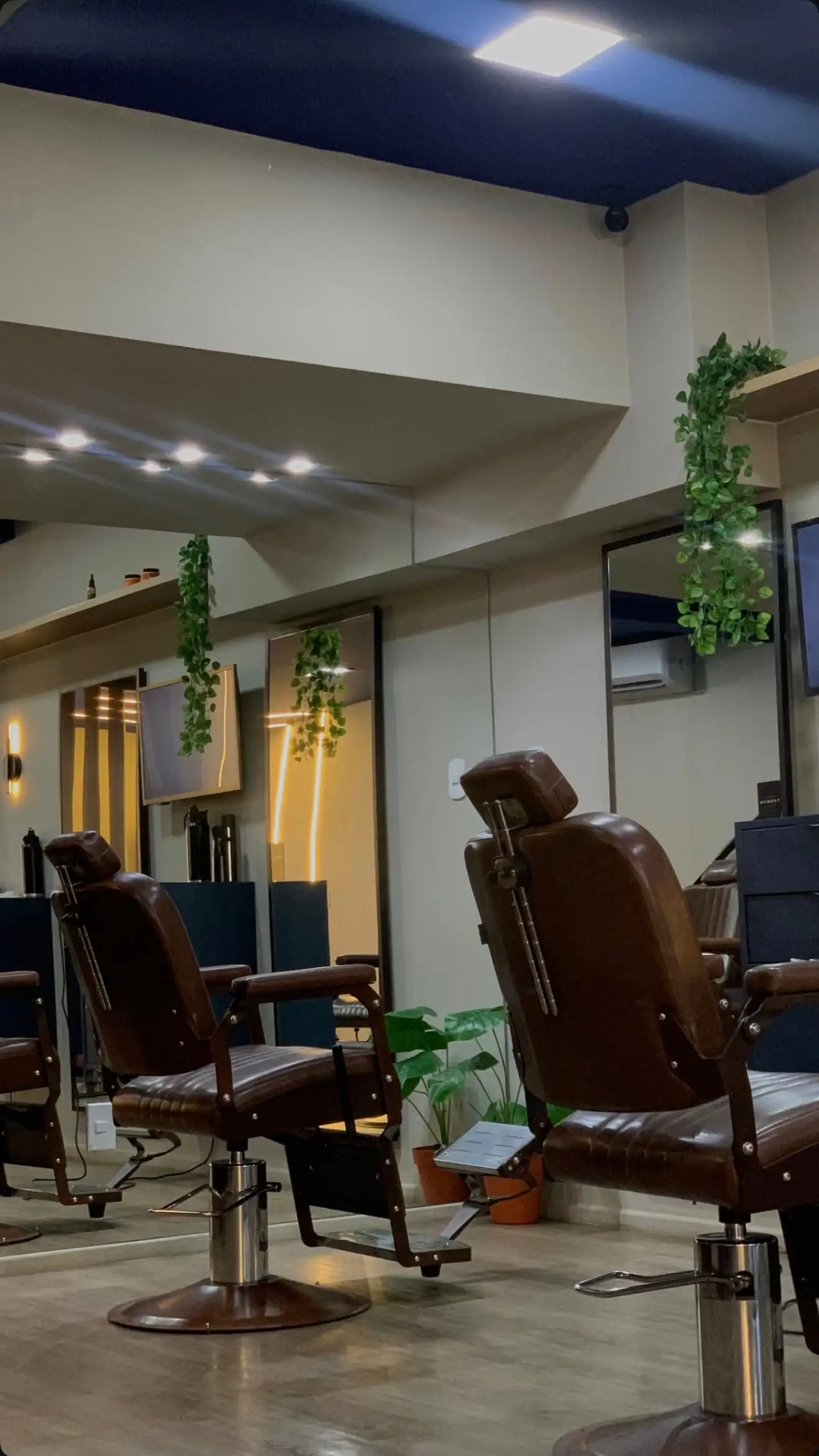 Salão principal com cadeiras de barbeiro em couro