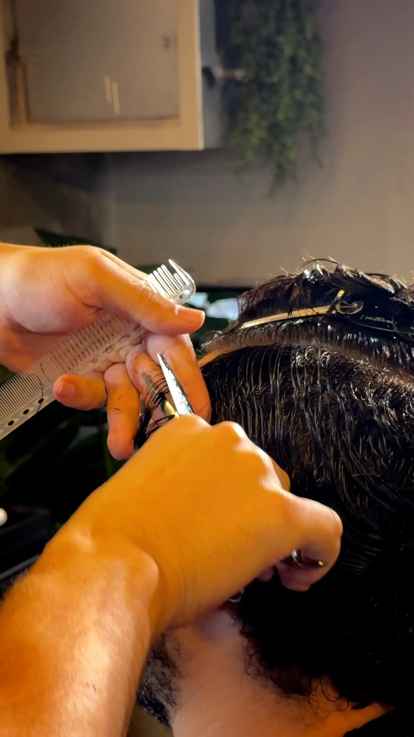Barbeiro cortando cabelo com tesoura e pente na Your Moment